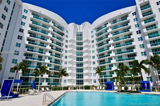a row of palm trees in front of a building