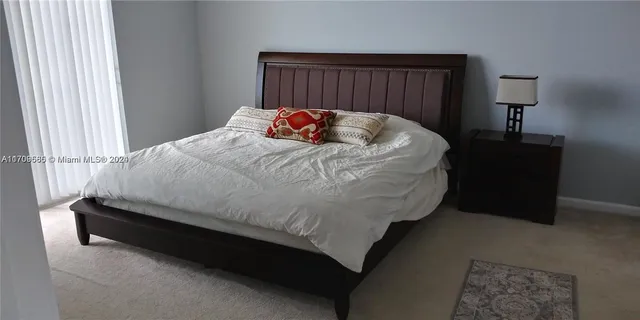 a bed sitting in a bedroom next to a lamp