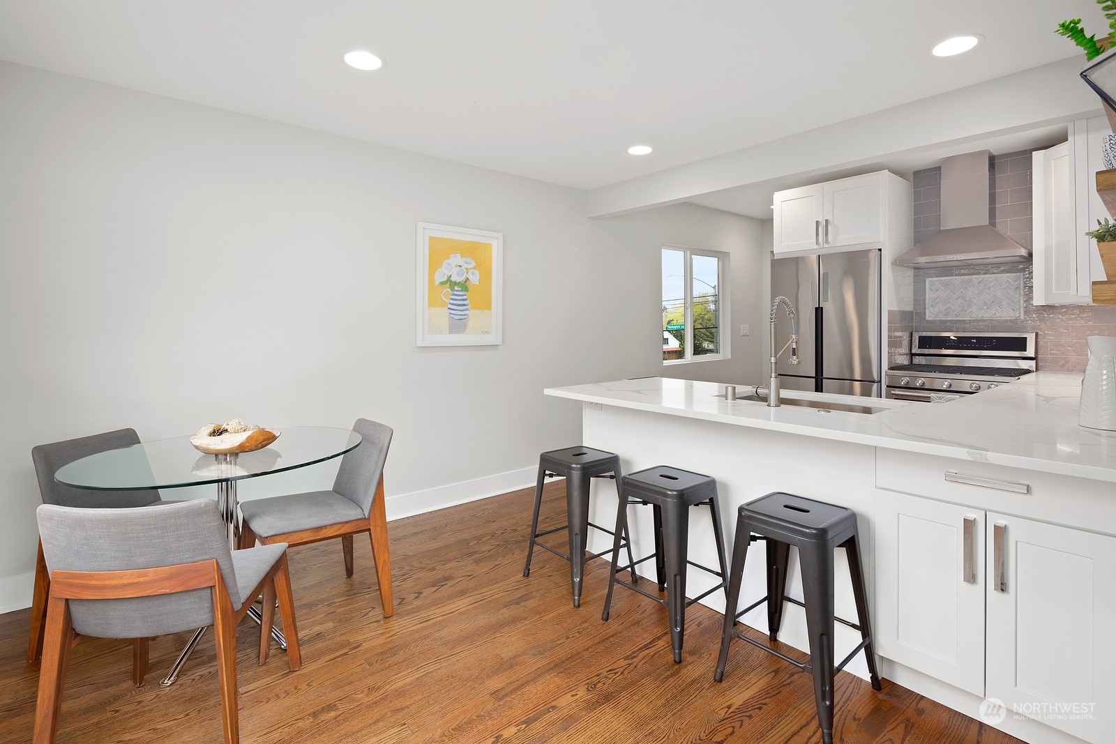 8510 Wallingford Avenue North, Unit A Seattle, WA 98103 - Photo 13 of 36 a kitchen with stainless steel appliances granite countertop a dining table chairs and wooden floor