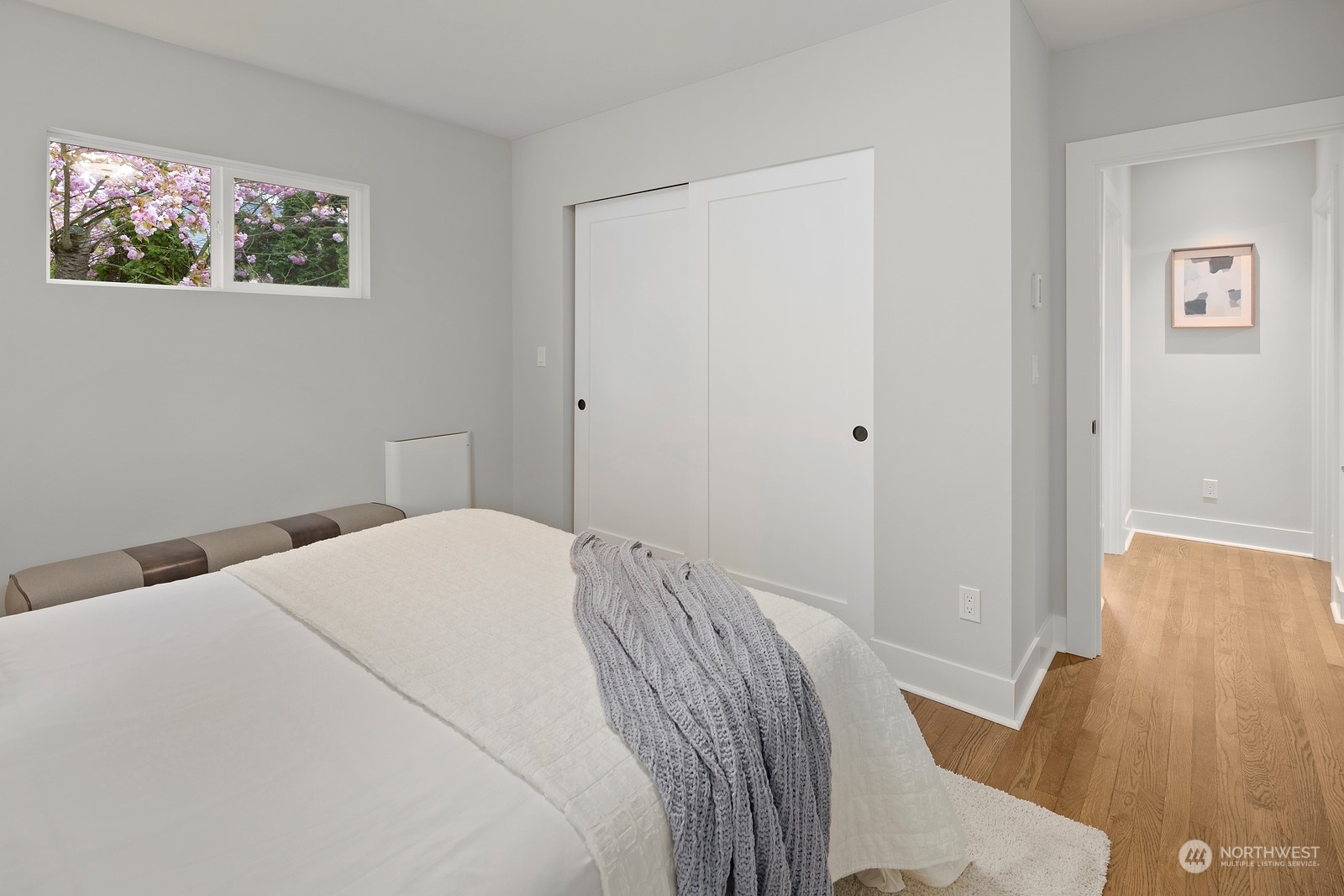 8510 Wallingford Avenue North, Unit A Seattle, WA 98103 - Photo 17 of 36 a bedroom with a bed and wooden floor