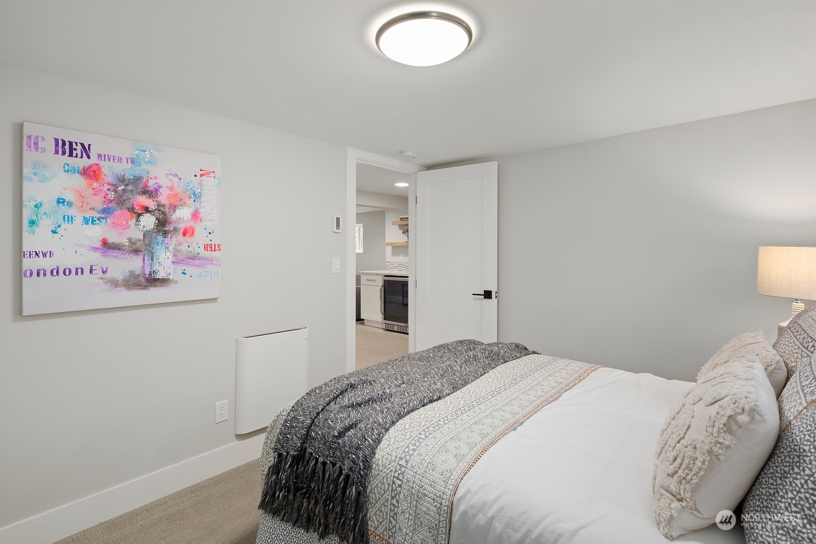 8510 Wallingford Avenue North, Unit A Seattle, WA 98103 - Photo 29 of 36 a bedroom with a bed and wall painting