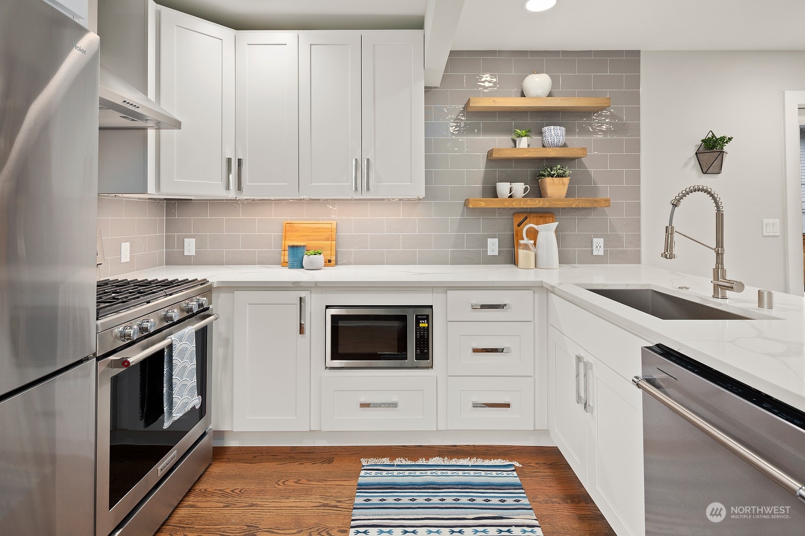 8510 Wallingford Avenue North, Unit A Seattle, WA 98103 - Photo 9 of 36 a kitchen with stainless steel appliances white cabinets and a stove