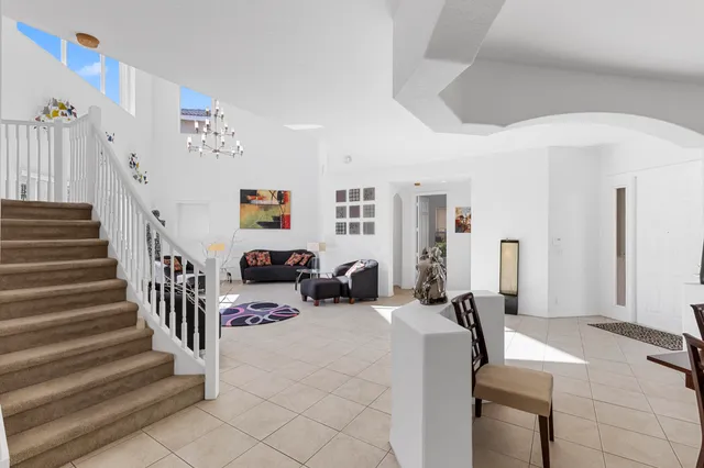 a living room with furniture a flat screen tv and a large window