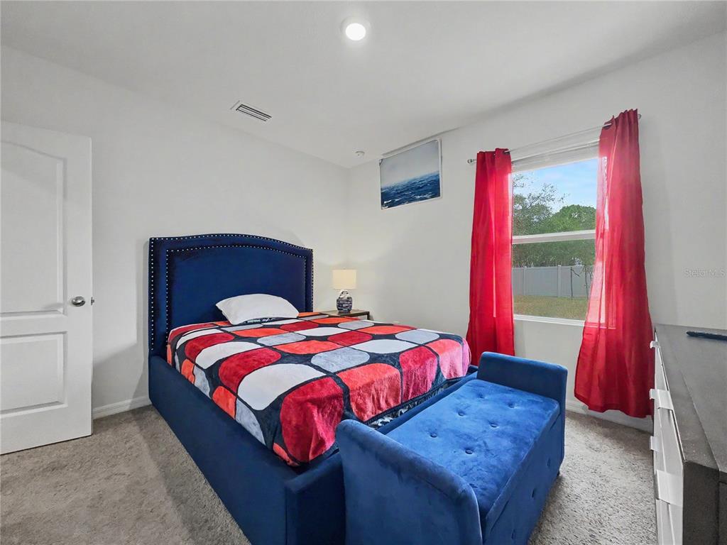 2085 Doe Run Drive Davenport, FL 33837 - Photo 21 of 44 a bedroom with a bed and a wooden floor