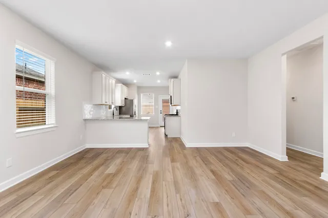 a view of kitchen with wooden floor electronic appliances and window