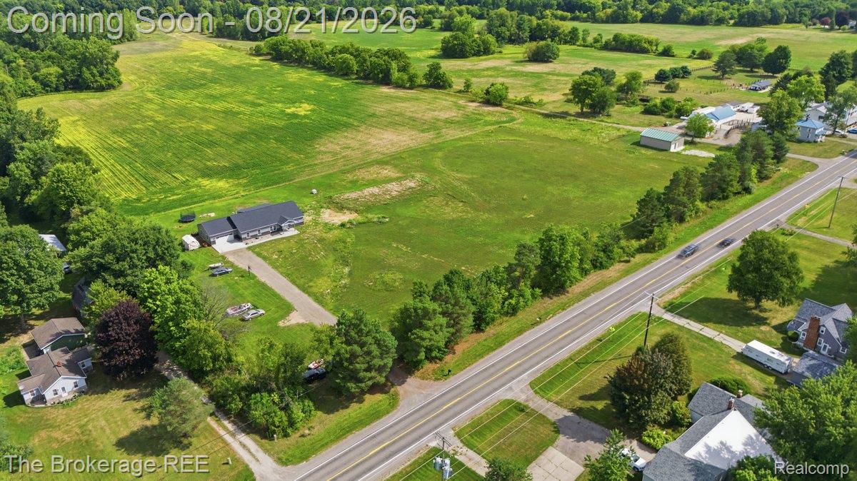 9161 East Coldwater Road Davison, MI 48423 - Photo 40 of 52 Expansive green fields, wooded borders, and a paved two-lane road
