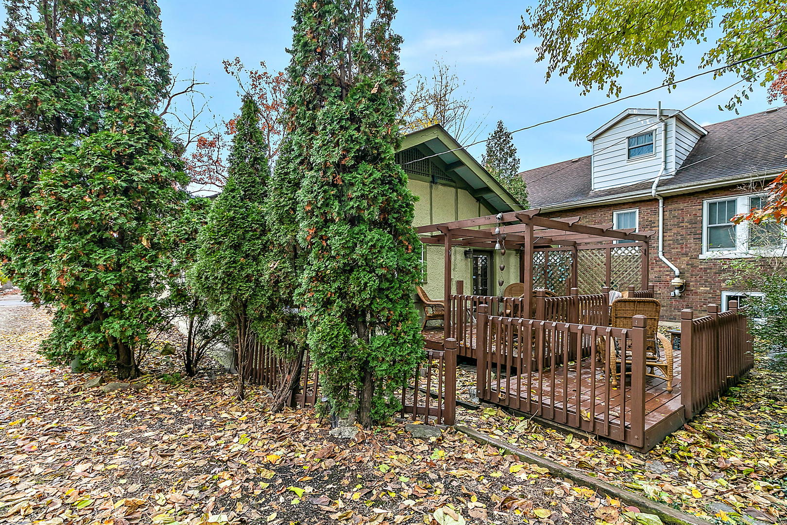 128 Barrypoint Road Riverside, IL 60546 - Photo 15 of 27 a view of a house with large trees and wooden fence
