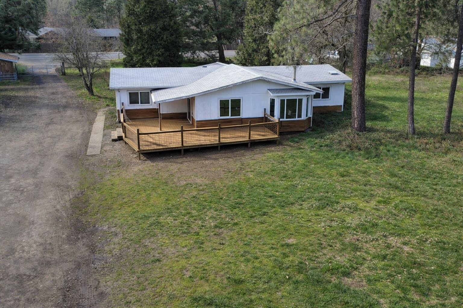1449 Rockydale Road Cave Junction, OR 97523 - Photo 3 of 11 a house with trees in front of it