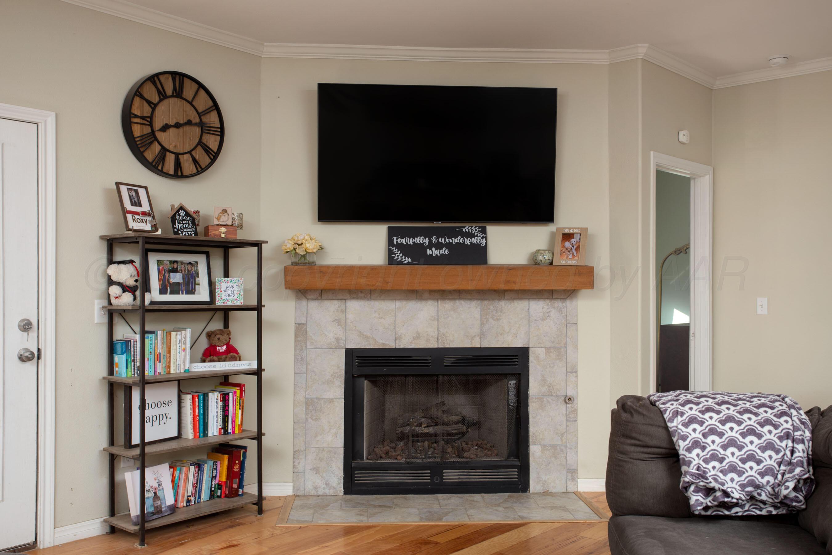 9505 Perry Avenue Amarillo, TX 79119 - Photo 4 of 21 a living room with television and a fireplace