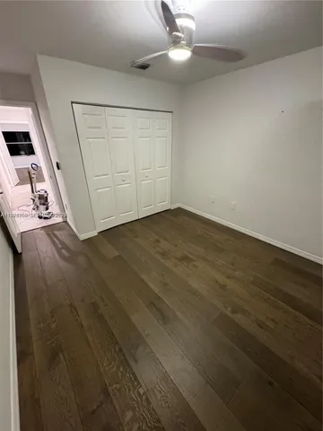 an empty room with wooden floor sink and cabinet