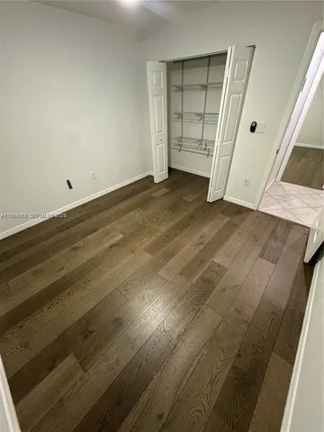 an empty room with wooden floor and closet