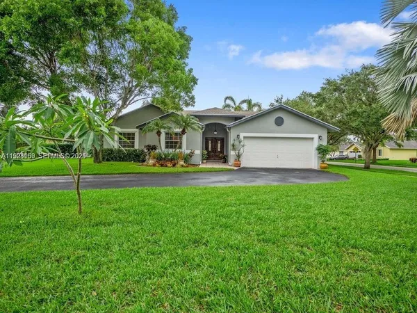 a front view of a house with plants and garden