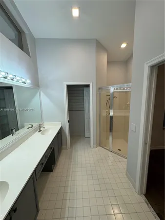a bathroom with a double vanity sink a mirror and a shower