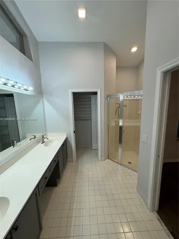 a bathroom with a double vanity sink a mirror and a shower