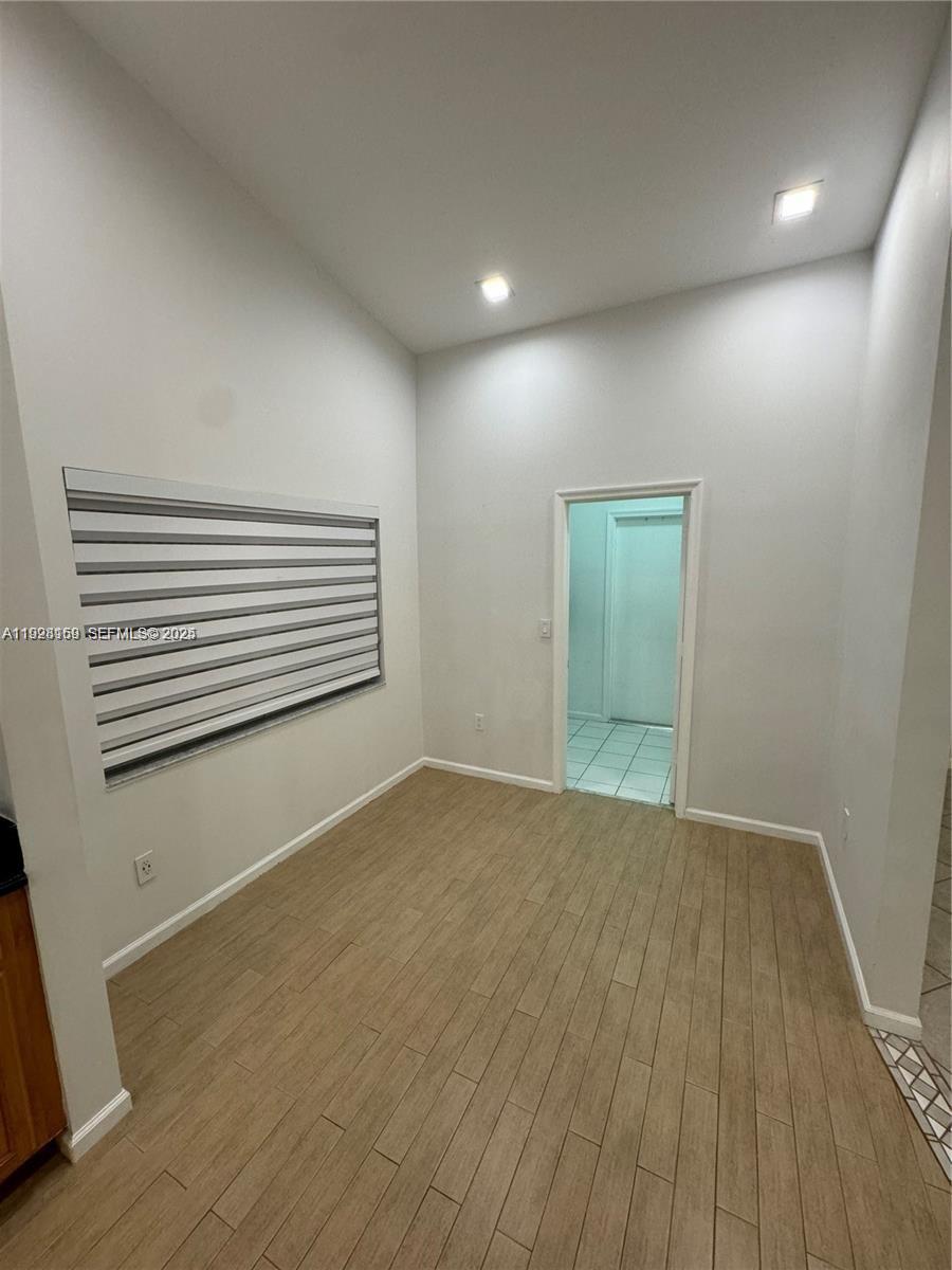 8965 Southwest 59th Court Cooper City, FL 33328 - Photo 26 of 34 a view of an empty room with wooden floor and a window