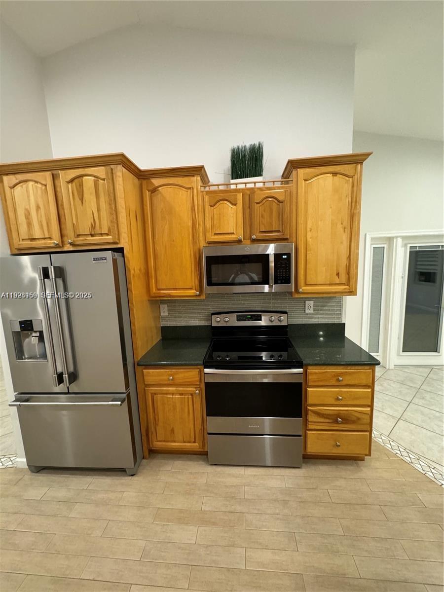 8965 Southwest 59th Court Cooper City, FL 33328 - Photo 27 of 34 a kitchen with stainless steel appliances a stove a microwave and a refrigerator