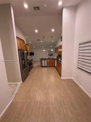 a view of a kitchen with a sink and a refrigerator
