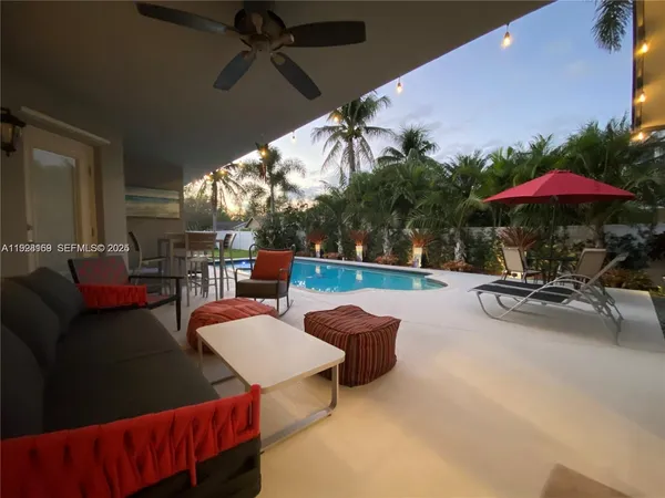 a view of a patio with a table and chairs under an umbrella
