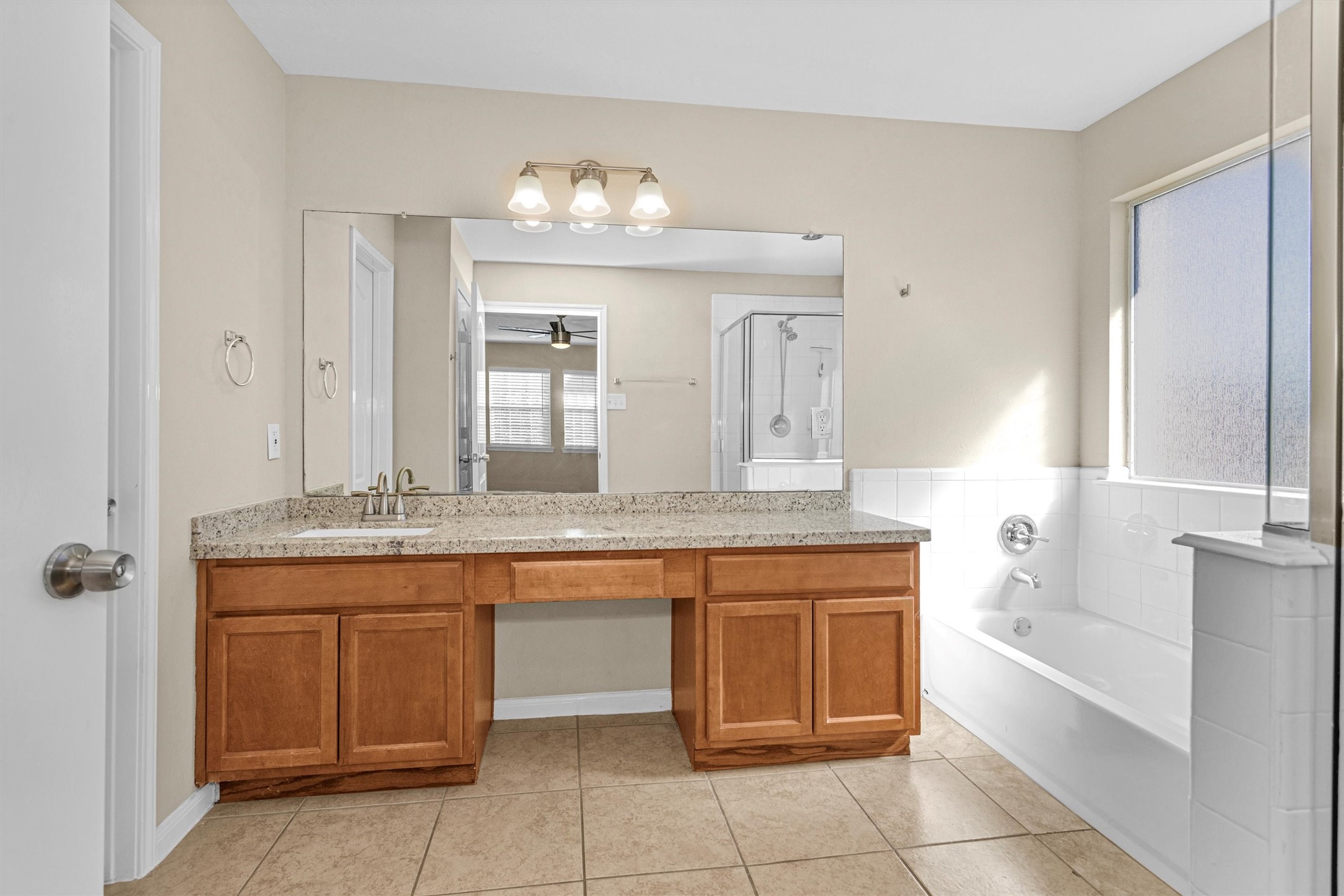 29710 Legends Ranch Court Spring, TX 77386 - Photo 13 of 20 a bathroom with a granite countertop sink a large mirror and a bathtub