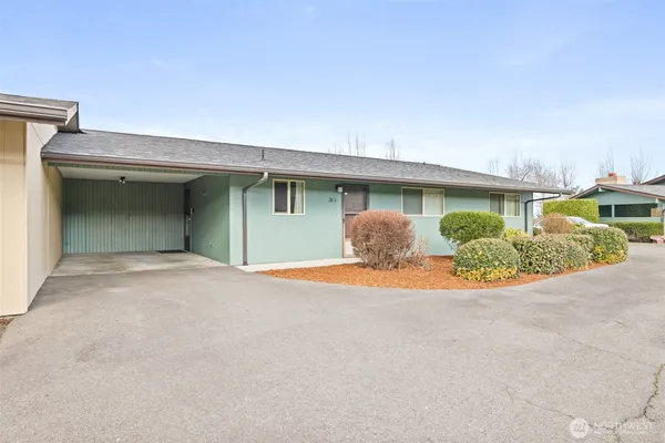 a view of an house with backyard and bushes