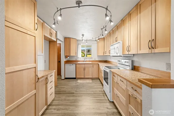 a kitchen with stainless steel appliances white cabinets and wooden floors