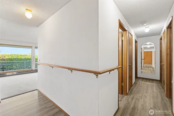 a view of hallway with a large window and wooden floor