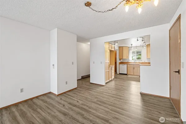 a view of a kitchen with wooden floor and a refrigerator