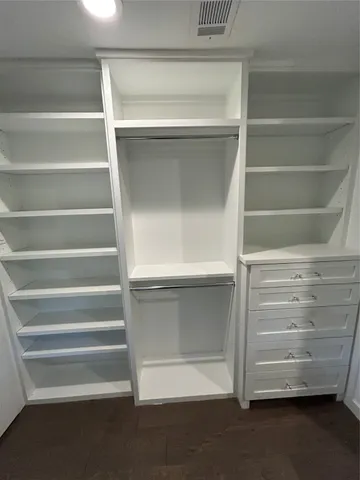 a view of walk in closet with empty racks