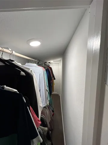 a view of walk in closet with clothes and shoes