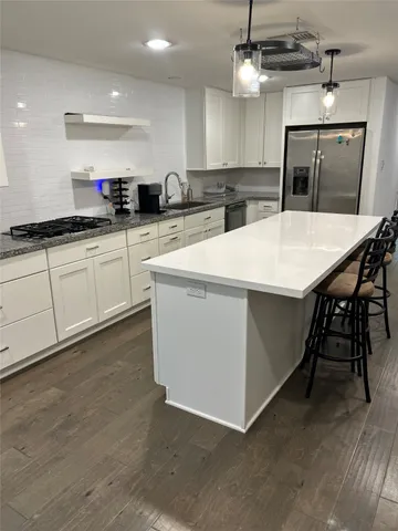 a large kitchen with a table and chairs