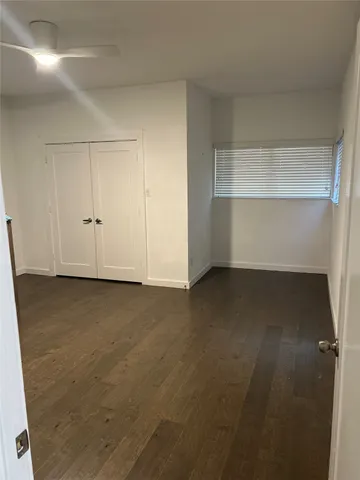 an empty room with wooden floor and cabinet