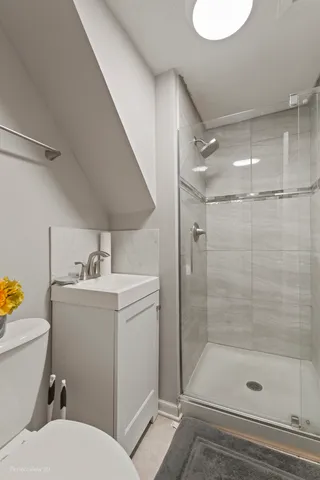 a bathroom with a sink a toilet and shower