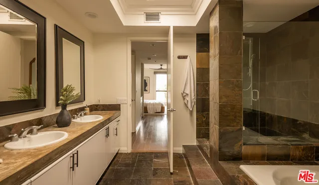 a bathroom with double vanity and a shower