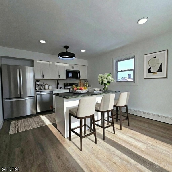 8 Berry Street, Unit 2 Dover, NJ 07801 - Photo 14 of 19 a kitchen with stainless steel appliances a dining table chairs refrigerator and cabinets