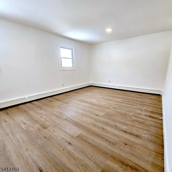 8 Berry Street, Unit 2 Dover, NJ 07801 - Photo 17 of 19 a view of an empty room with wooden floor and a window