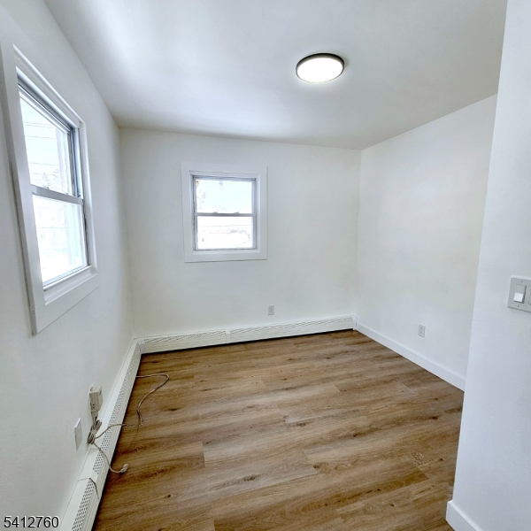 8 Berry Street, Unit 2 Dover, NJ 07801 - Photo 4 of 19 wooden floor in an empty room with a window