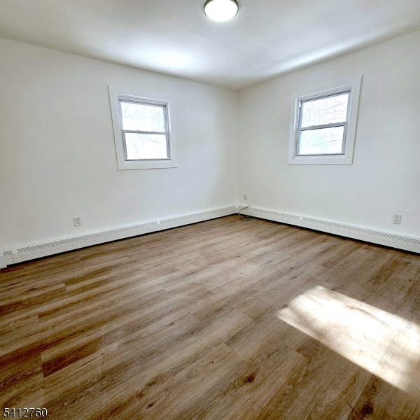 8 Berry Street, Unit 2 Dover, NJ 07801 - Photo 6 of 19 a view of an empty room with wooden floor and a window