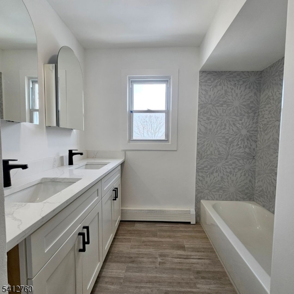 8 Berry Street, Unit 2 Dover, NJ 07801 - Photo 7 of 19 a spacious bathroom with a granite countertop sink a bathtub a mirror and vanity