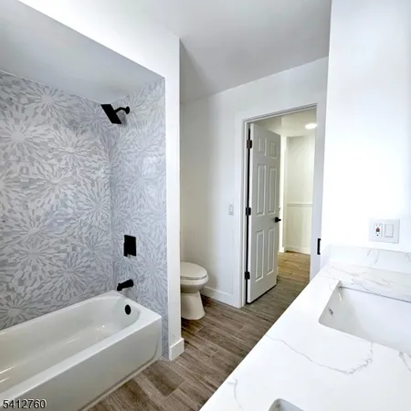 a bathroom with a tub a toilet and a shower