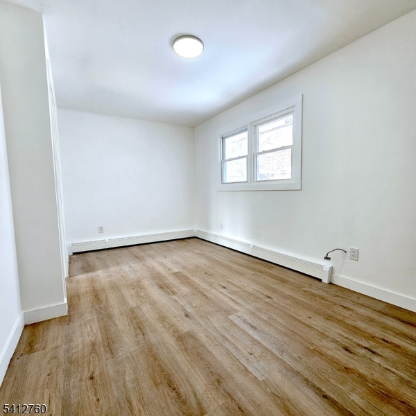 8 Berry Street, Unit 2 Dover, NJ 07801 - Photo 10 of 19 an empty room with wooden floor and windows
