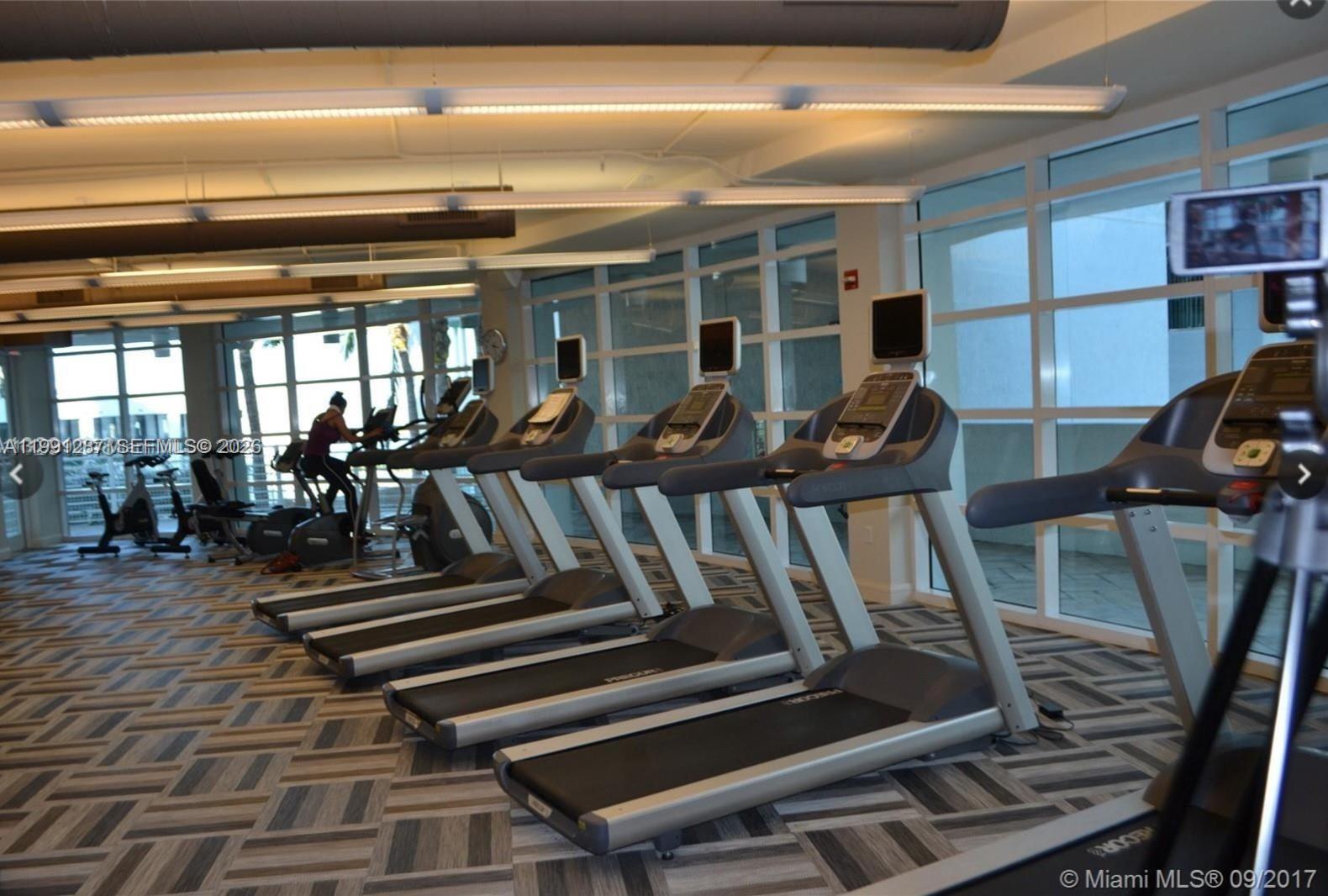 253 Northeast 2nd Street, Unit 905 Miami, FL 33132 - Photo 15 of 20 a view of a room with lots of wooden furniture