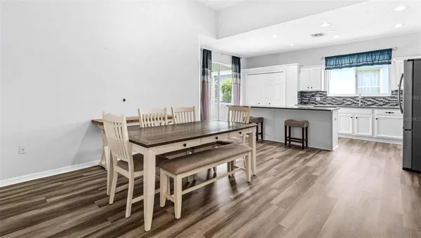 a kitchen with a stove a sink and white cabinets with wooden floor