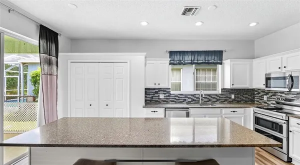 a kitchen with stainless steel appliances granite countertop a stove and a sink with granite countertops
