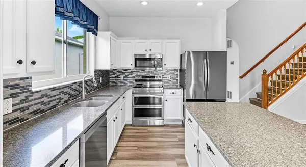a kitchen with stainless steel appliances granite countertop a stove and a sink