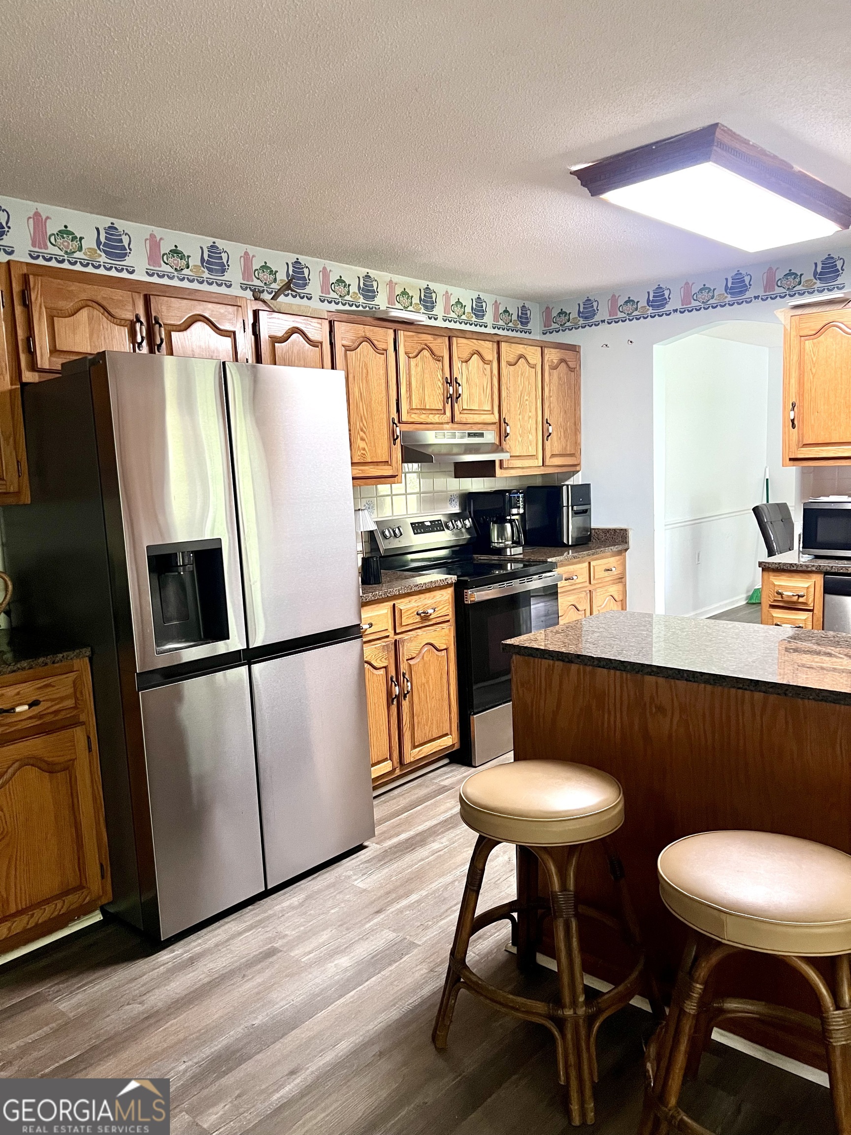 46 Ray Roderick Road Eastman, GA 31023 - Photo 15 of 22 a kitchen with stainless steel appliances granite countertop a sink a stove a refrigerator a dining table and chairs