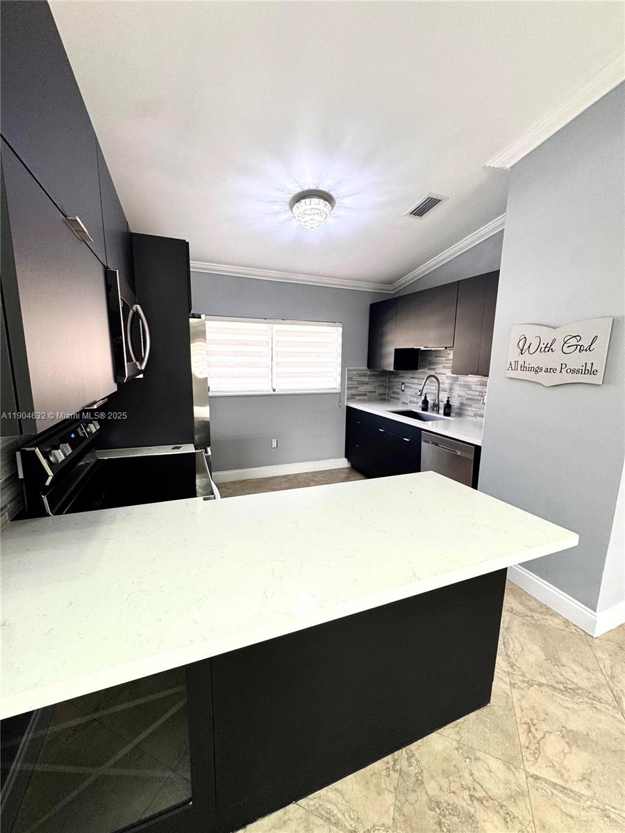 7870 West 29th Way, Unit 201 Hialeah, FL 33018 - Photo 6 of 18 a kitchen with kitchen island sink and stove