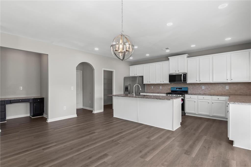 9120 Alden Drive Locust Grove, GA 30248 - Photo 19 of 39 a kitchen with stainless steel appliances granite countertop a white cabinets a sink dishwasher and a stove with wooden floor
