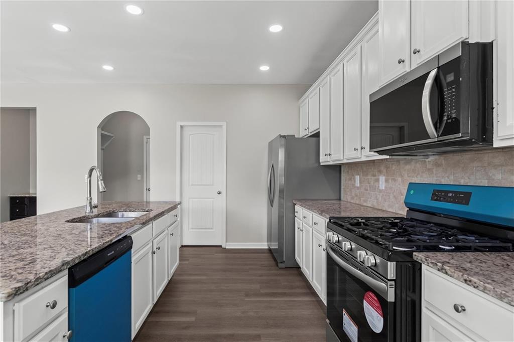9120 Alden Drive Locust Grove, GA 30248 - Photo 21 of 39 a kitchen with stainless steel appliances granite countertop a stove a sink and a microwave