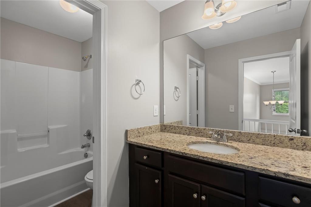 9120 Alden Drive Locust Grove, GA 30248 - Photo 38 of 39 a bathroom with a granite countertop sink a mirror and a bathtub