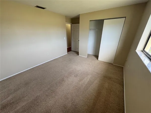 an empty room with closet and mirror